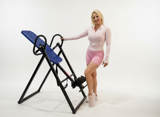 Woman standing next to an inversion table on a white background
